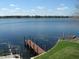 Scenic lake view featuring a long wooden pier and grassy shoreline at 1500 Gay Rd # 10C, Winter Park, FL 32789