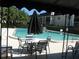 Beautiful pool area featuring lounge chairs, an umbrella, and lush landscaping at 1500 Gay Rd # 10C, Winter Park, FL 32789