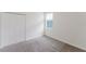 An empty bedroom with carpet, a window and double door closet at 16462 Glassy Loch Loop, Clermont, FL 34714