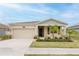 Inviting one-story home boasting a two-car garage, stone accents, and neatly arranged landscaping at 16462 Glassy Loch Loop, Clermont, FL 34714