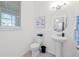 Bright bathroom with a pedestal sink, modern fixtures, and a large window at 16560 Point Rock Dr, Winter Garden, FL 34787