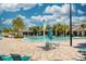 Beautiful resort-style community pool featuring ample lounge seating, palm trees, and sunny skies at 16560 Point Rock Dr, Winter Garden, FL 34787