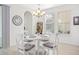 Cozy dining area with a round table, white chairs with gray cushions, and bright natural lighting at 16560 Point Rock Dr, Winter Garden, FL 34787