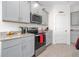 Close up of a modern kitchen featuring stainless steel appliances, and gray cabinets at 16560 Point Rock Dr, Winter Garden, FL 34787