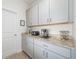 View of the pantry featuring grey cabinets, granite countertops, and small appliances at 16560 Point Rock Dr, Winter Garden, FL 34787