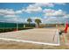 Sandy community volleyball court by the lake, with puffy white clouds in a bright blue sky at 16560 Point Rock Dr, Winter Garden, FL 34787