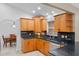 Well-lit kitchen features wooden cabinets, black countertops, and tiled backsplash at 1971 Urbana Ave, Deltona, FL 32725