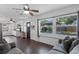 Spacious living room with dark wood floors, a grey sofa, and a view of the backyard at 1971 Urbana Ave, Deltona, FL 32725