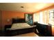 View of the bedroom with a bed, dresser, orange walls and natural light at 214 E 18Th St, Sanford, FL 32771