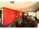 View of the living room featuring hardwood floors, a red accent wall and a view into the dining room at 214 E 18Th St, Sanford, FL 32771