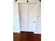 A pair of white closet doors, hardwood floors and white walls are visible at 214 N New Hampshire Ave, Tavares, FL 32778