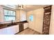 Stylish kitchen features white cabinets, stainless appliances, wood counters, and brick accent wall at 214 N New Hampshire Ave, Tavares, FL 32778
