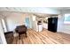 Open-concept living room featuring hardwood floors, a black fridge, and wood floors at 214 N New Hampshire Ave, Tavares, FL 32778