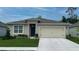 One-story home with beige exterior, a two-car garage, and well-manicured lawn at 2148 Pigeon Plum Dr, Haines City, FL 33844