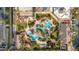 Stunning aerial view of community resort-style pool with lush landscaping, beach volleyball court, and ample parking at 2153 Calabria Ave, Davenport, FL 33897