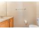 Half bathroom features a single sink vanity, toilet, and light beige walls at 2153 Calabria Ave, Davenport, FL 33897