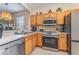 Bright kitchen with stainless steel appliances, light wood cabinets, and tiled floor at 2153 Calabria Ave, Davenport, FL 33897