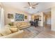 Open-concept living and dining area with hardwood floors, ceiling fan, and seamless flow into the kitchen at 2153 Calabria Ave, Davenport, FL 33897