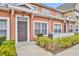 Exterior shot of a townhouse with a brown door and white picket fence at 2200 San Vittorino Cir # 104, Kissimmee, FL 34741