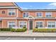 Charming two-story townhome featuring peach siding, a well-manicured lawn, and a quaint white picket fence at 2200 San Vittorino Cir # 104, Kissimmee, FL 34741