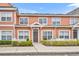 Charming two-story townhome featuring peach siding, a well-manicured lawn, and a quaint white picket fence at 2200 San Vittorino Cir # 104, Kissimmee, FL 34741