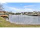 Scenic view of a community pond featuring a wooden dock and fountain with colorful townhomes in the distance at 2200 San Vittorino Cir # 104, Kissimmee, FL 34741