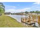 Scenic view of a community pond featuring a wooden dock and fountain with colorful townhomes in the distance at 2200 San Vittorino Cir # 104, Kissimmee, FL 34741