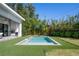 Backyard pool with artificial turf and an outdoor kitchen and grill area at 2412 Chantilly Ave, Winter Park, FL 32789