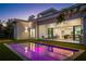 Backyard view of modern home and a sleek pool with vibrant neon lighting at dusk at 2412 Chantilly Ave, Winter Park, FL 32789