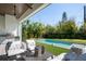 Outdoor seating area with summer kitchen overlooks the sparkling pool and manicured backyard at 2412 Chantilly Ave, Winter Park, FL 32789