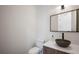 Stylish powder room featuring modern fixtures, a unique vessel sink, and a wood-look vanity at 2412 Chantilly Ave, Winter Park, FL 32789