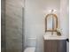 Bright bathroom featuring grey tiled shower, modern vanity, and an arched wood framed mirror at 2412 Chantilly Ave, Winter Park, FL 32789