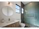 Bright bathroom with marble style shower, modern vanity, and framed round mirror at 2412 Chantilly Ave, Winter Park, FL 32789