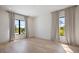 Spacious empty bedroom featuring hardwood floors, black framed windows, and modern curtains at 2412 Chantilly Ave, Winter Park, FL 32789