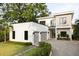 Modern home featuring a sleek white exterior, two-car garage, and a balcony with black metal railings at 2412 Chantilly Ave, Winter Park, FL 32789