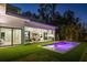 Twilight aerial view of the modern home featuring pool, backyard, outdoor kitchen and lush landscaping at 2412 Chantilly Ave, Winter Park, FL 32789