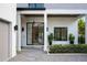 Elegant entryway featuring a modern glass door, stone path, and stylish landscaping at 2412 Chantilly Ave, Winter Park, FL 32789