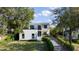 Two story modern home with landscaping, gravel drive and a walkway leading to a black glass front door at 2412 Chantilly Ave, Winter Park, FL 32789