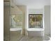 Spa-like main bathroom with a soaking tub, a glass-enclosed shower, and a view of the fenced yard at 2412 Chantilly Ave, Winter Park, FL 32789