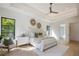Bright main bedroom boasts neutral tones, natural light, an ensuite bathroom, and a view to the outside at 2412 Chantilly Ave, Winter Park, FL 32789