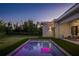 Twilight view of the backyard featuring the in-ground pool with LED lighting and outdoor entertaining space at 2412 Chantilly Ave, Winter Park, FL 32789