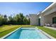 Bright, sunny day shows the in-ground pool, stone deck, and grassy area in the backyard of this home at 2412 Chantilly Ave, Winter Park, FL 32789