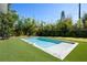 Beautiful backyard pool surrounded by lush landscaping and green artificial turf at 2412 Chantilly Ave, Winter Park, FL 32789