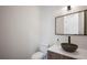 Stylish powder room featuring a vessel sink, modern faucet, and a wood-framed mirror at 2412 Chantilly Ave, Winter Park, FL 32789