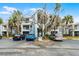 Exterior view of a well-maintained condo building with ample parking and lush tropical landscaping at 2521 Grassy Point Dr # 309, Lake Mary, FL 32746