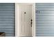 Clean white front door with secure lockset, knocker, and unit number on a lovely blue building at 2521 Grassy Point Dr # 309, Lake Mary, FL 32746