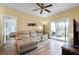 Living room with a ceiling fan, sliding glass doors to balcony, and a tan sectional at 2521 Grassy Point Dr # 309, Lake Mary, FL 32746