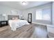 Well-lit bedroom featuring wood floors, a cozy bed, a mirror, and a window for ample natural light at 262 Orienta Point St # 1, Altamonte Springs, FL 32701