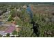 Aerial view of a cozy home with canal access, shaded by mature trees in a quiet neighborhood at 27622 Lois Dr, Tavares, FL 32778