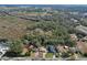 Aerial shot of a charming home situated amongst mature trees within a picturesque neighborhood at 27622 Lois Dr, Tavares, FL 32778